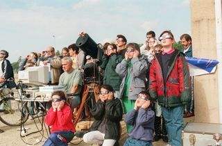 People observe a partial eclipse through special sunglasses 12 October 1996 in Saint Renan, western of France.