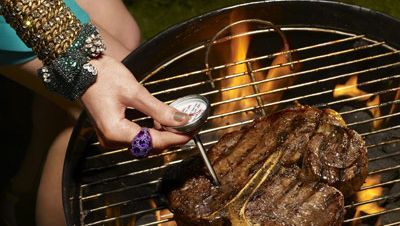 Woman testing temperature of steak