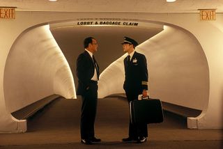 leonardo dicaprio as frank in a pilot uniform and a midcentury baggage claim in the movie Catch Me if You Can