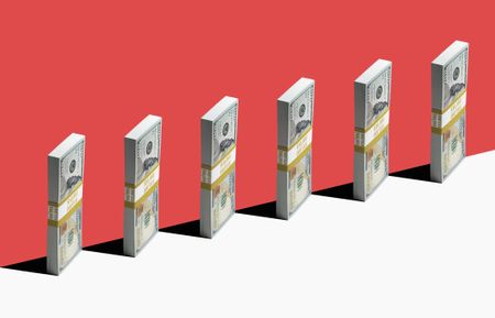 6 bundles of US $100 bills standing vertically on edge of white shelf, red background
