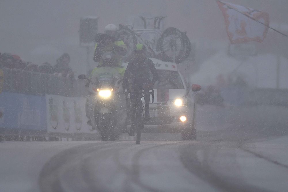 Barely visible in the heavy snowfall, Nairo Quintana approaches the finish.