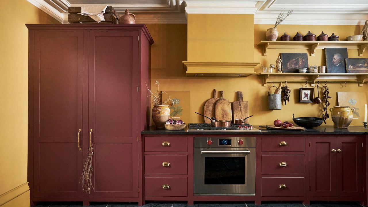 Burgundy shaker cabinets with mustard yellow walls in kitchen. 