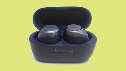 Jabra Elite Active 75t review: the earbuds in their charging case against a green background