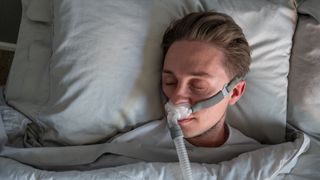 A man with sleep apnea wears a CPAP machine while sleeping