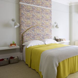 bedroom with white wall and bedside lamp and white pillow and yellow throw