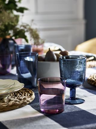 Dining tabletop with checked cloth and colored glassware
