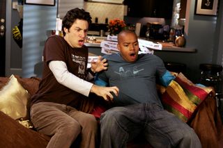 jd and turk look shocked while sitting on the couch in Scrubs