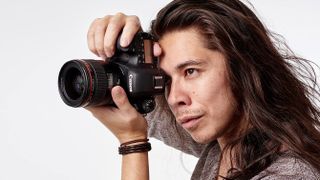 Man shooting with a Canon EOS 6D Mark II against a white backdrop