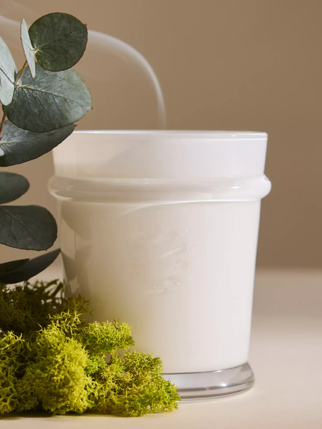A white glass candle from MERSEA with moss and eucalyptus
