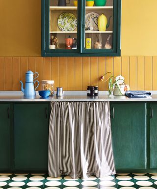 Yellow wall paint, green cabinets, white and green circle floor