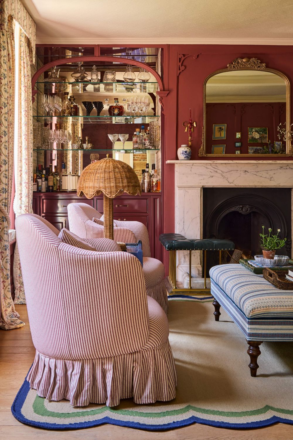 a red color drenched drawing room with ornate moldings, paneled walls, and a marble fireplace