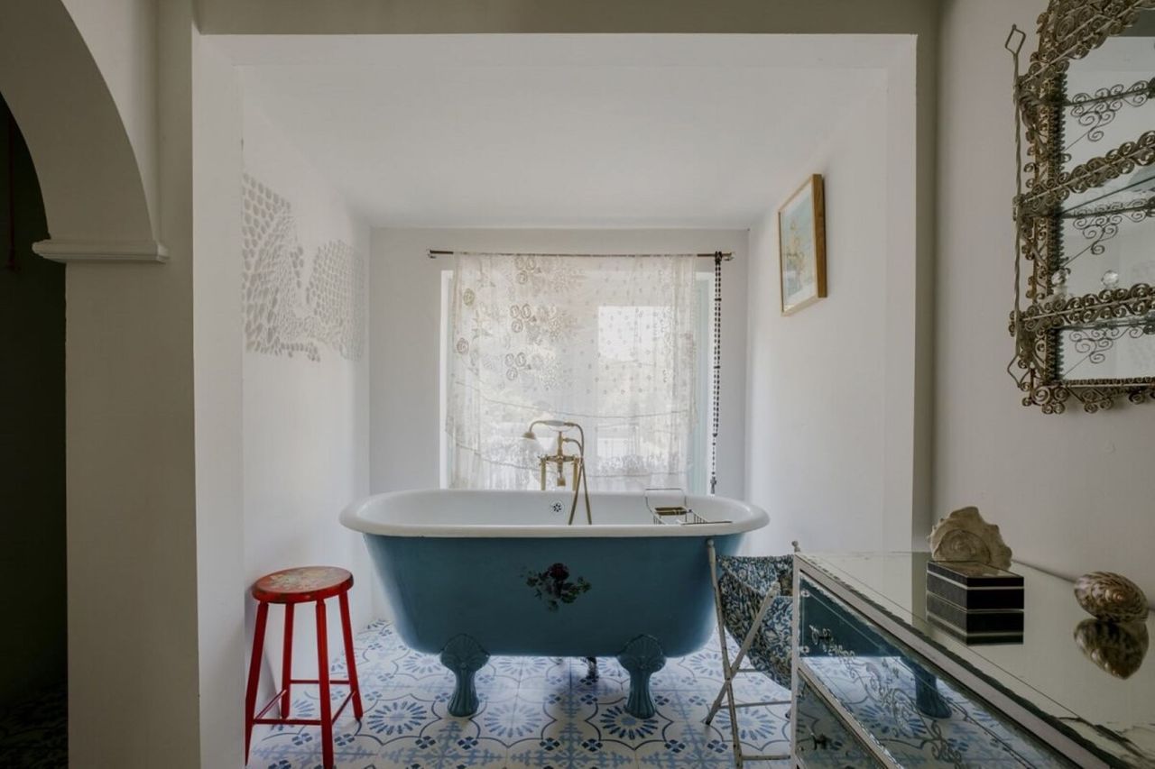 The Victorian tiled bathroom with a blue bath is an en suite to one of the bedrooms