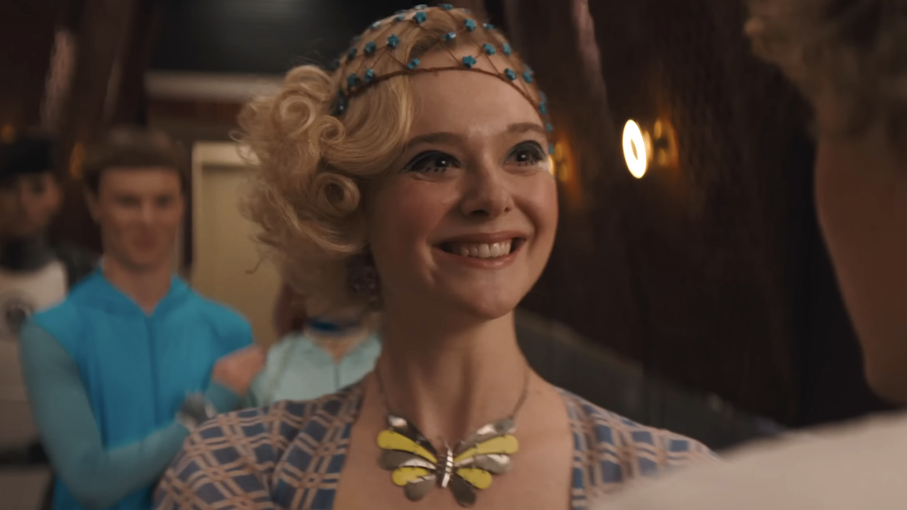 Elle Fanning smiling as Effie Trinket in Sunrise on the Reaping