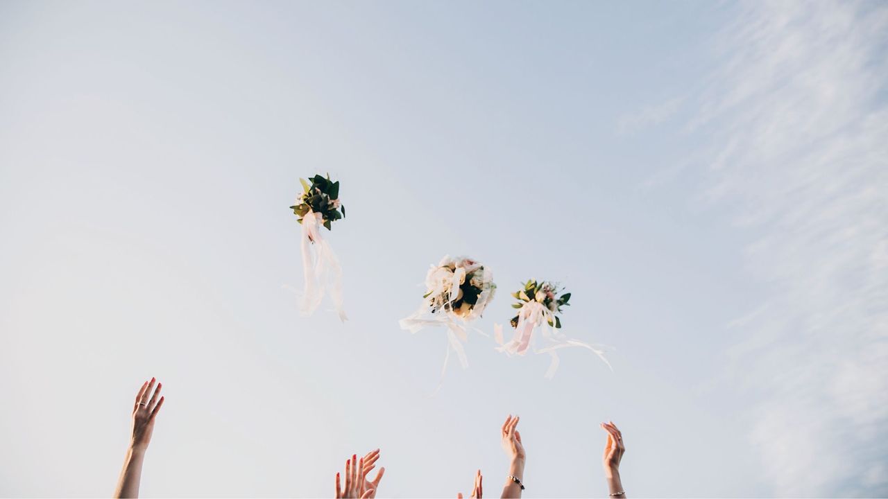 Wedding flower bouquets being thrown up to the sky