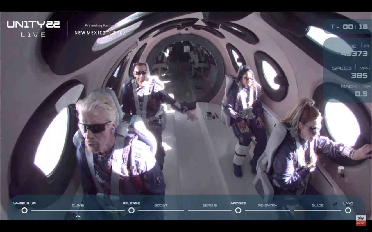 Virgin Group founder Richard Branson (left) and his fellow passengers in the cabin of VSS Unity during its fourth spaceflight, on July 11, 2021.