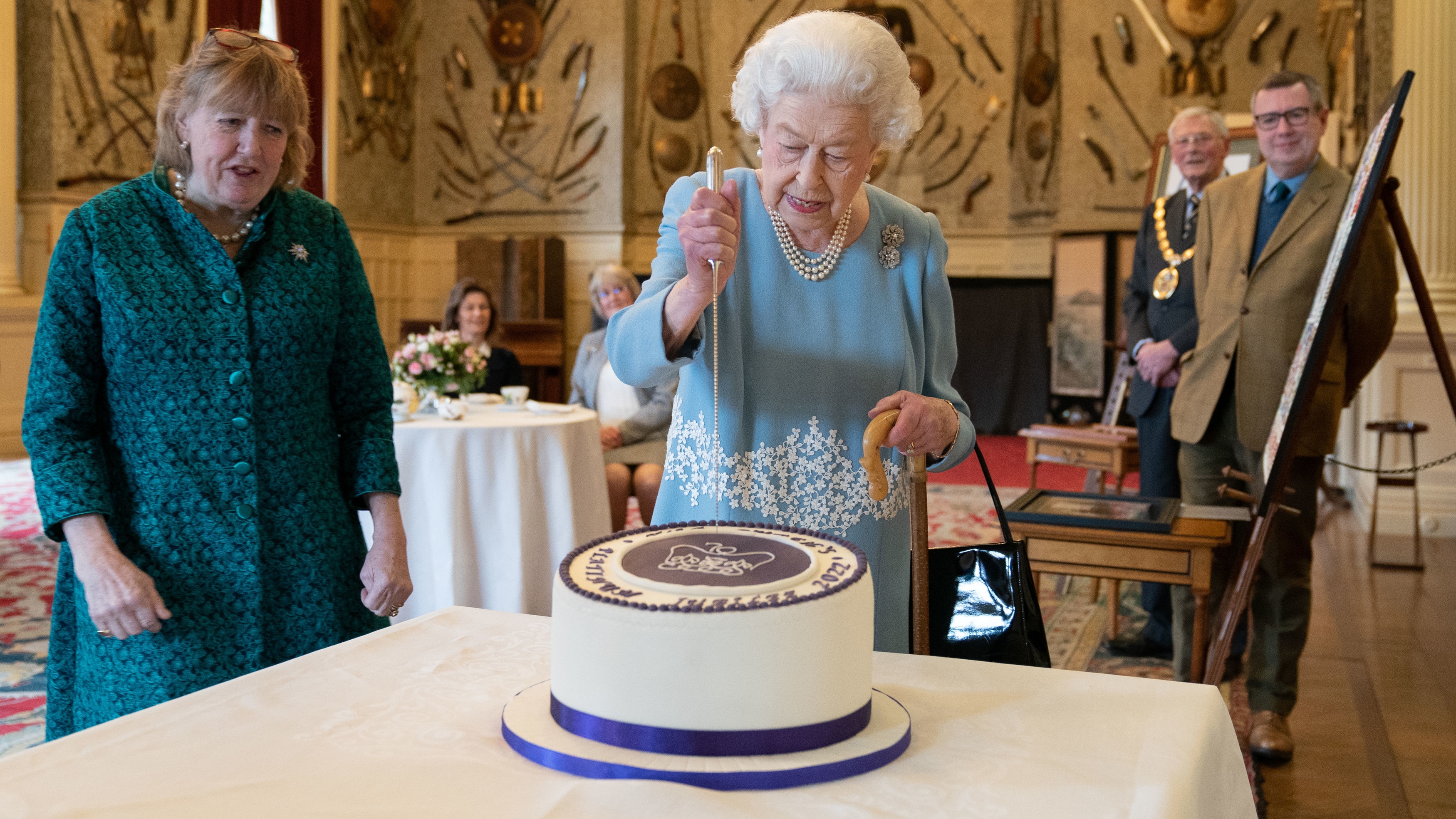 Queen Elizabeth II cuts a cake to celebrate the start of the Platinum Jubilee during a reception in the Ballroom of Sandringham House on February 5, 2022