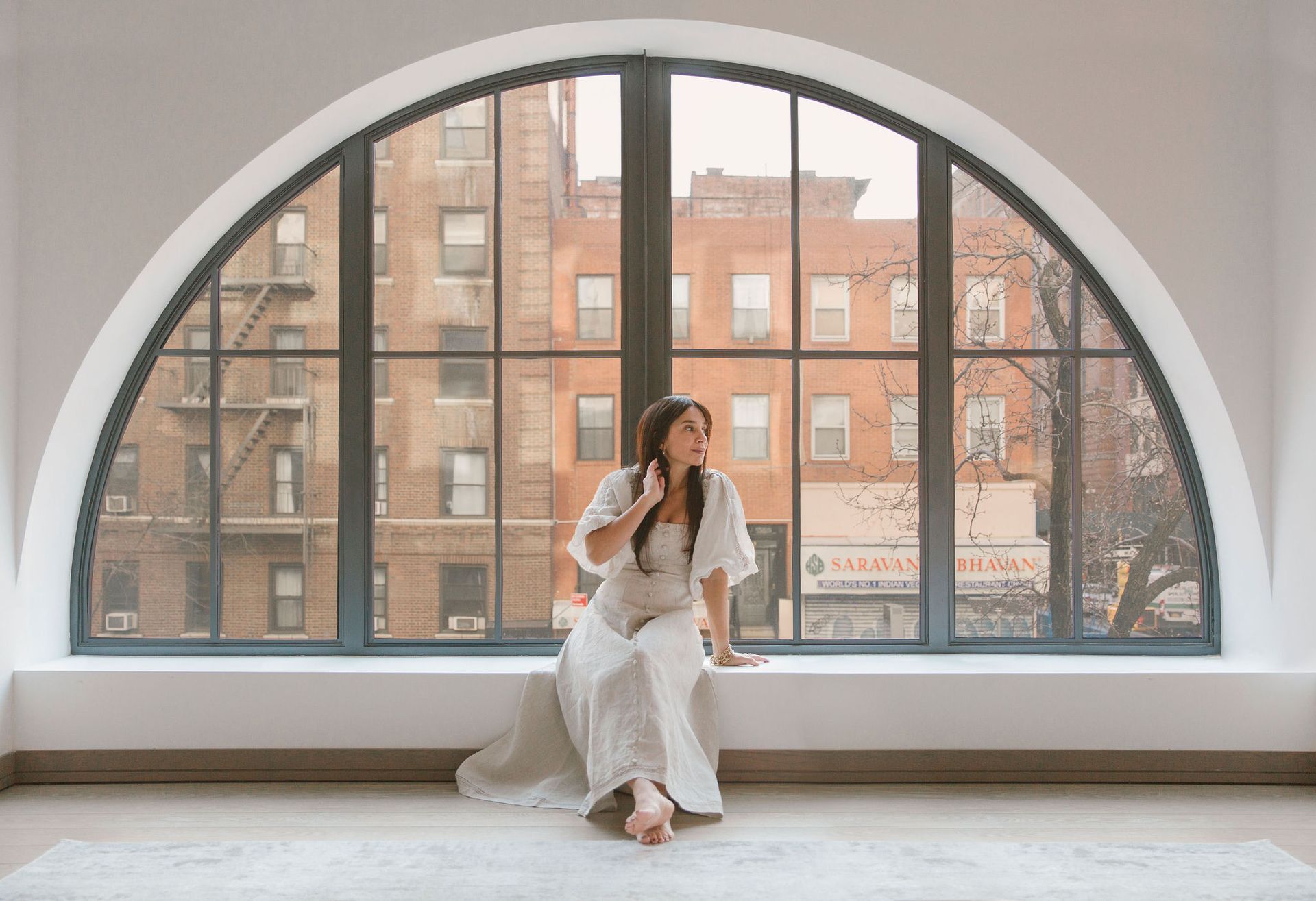 Sara Naghedi at home in a white dress