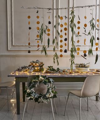 Hanging oranges and leaves from branch, fairy lights