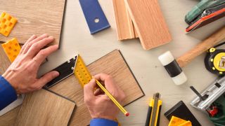 a person cutting laminate flooring with tools 