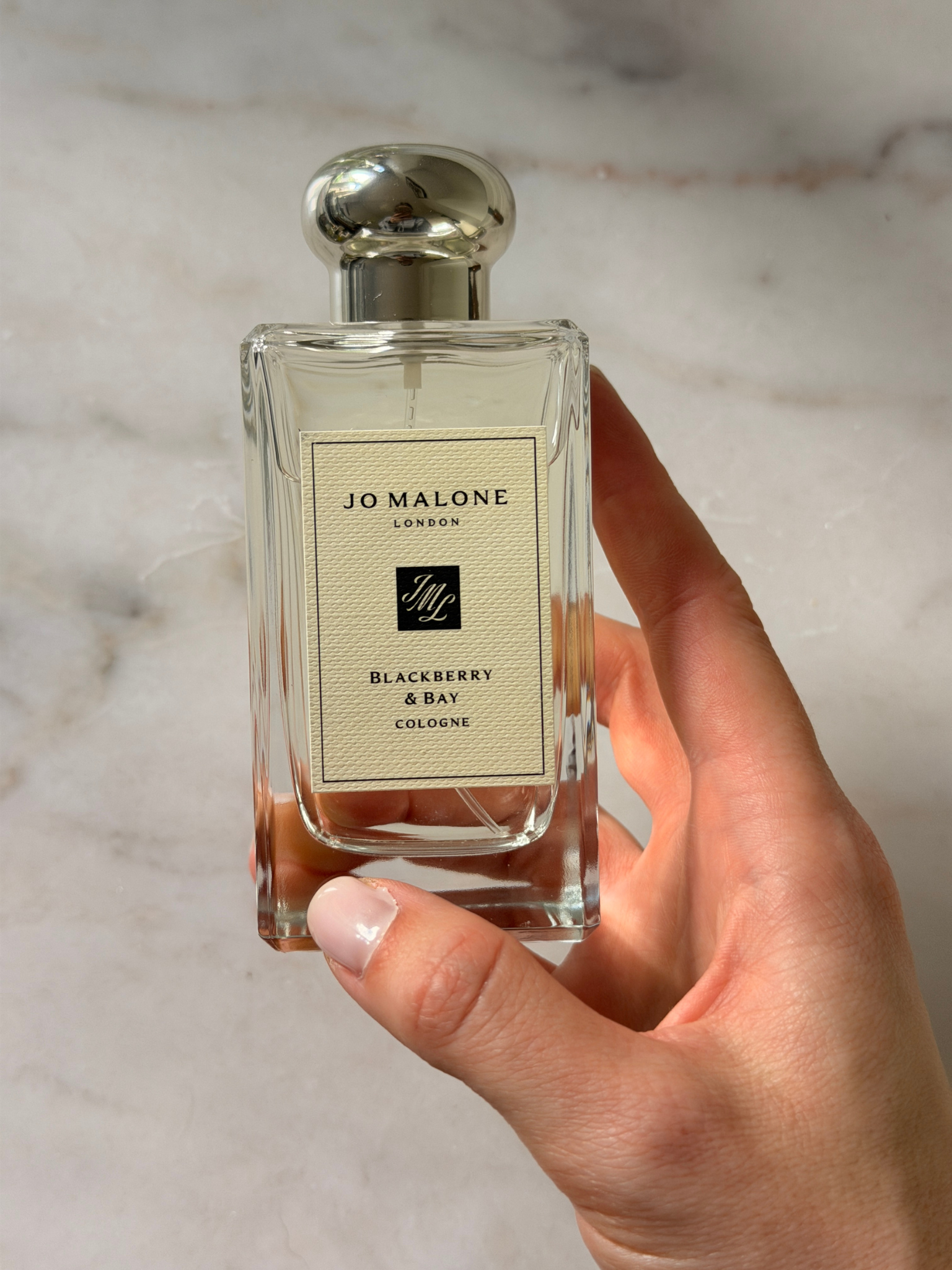 Grace holding a bottle of Jo Malone perfume