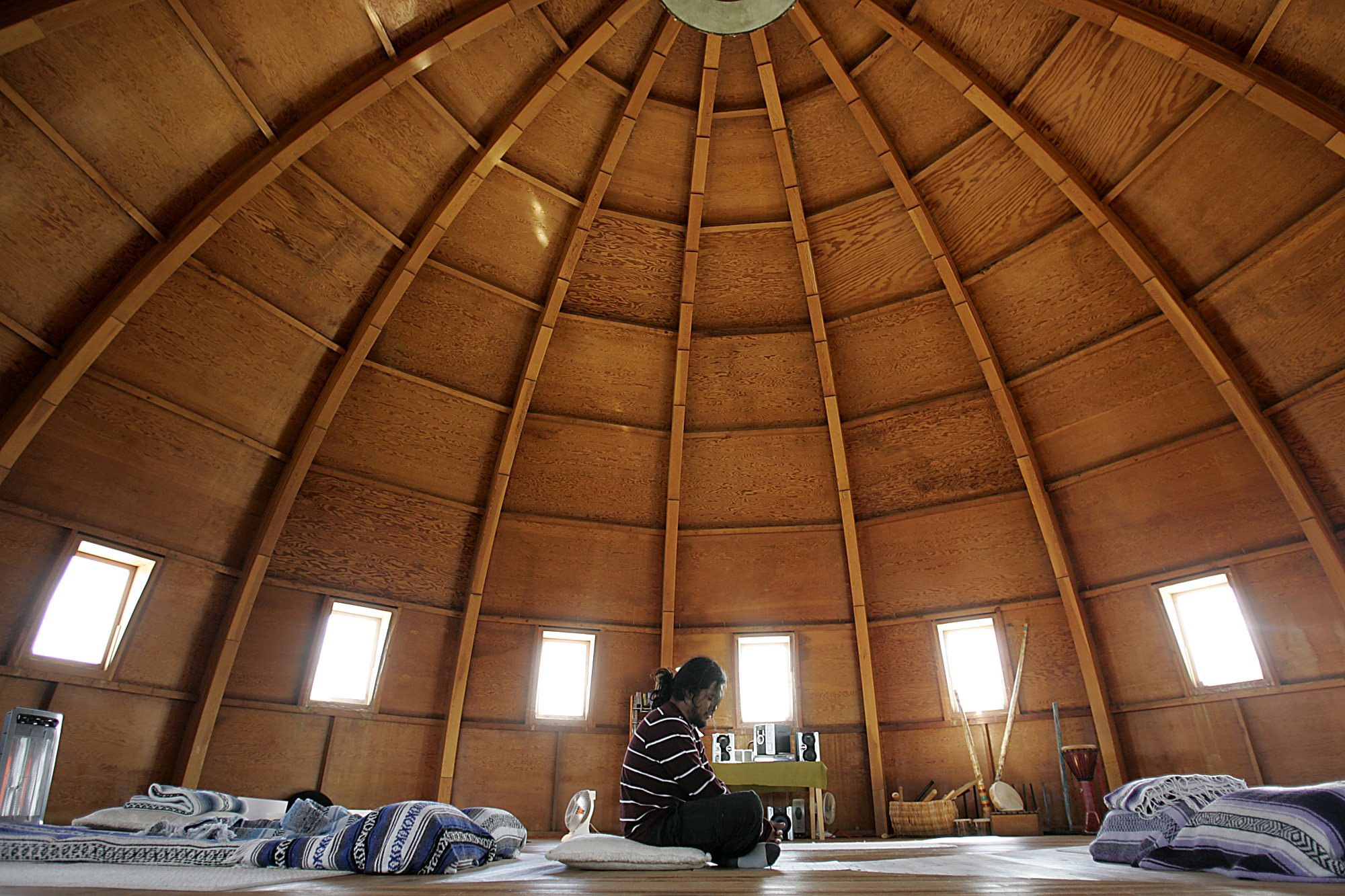 A man sits under the wooden dome at the Integratron in Landers, California