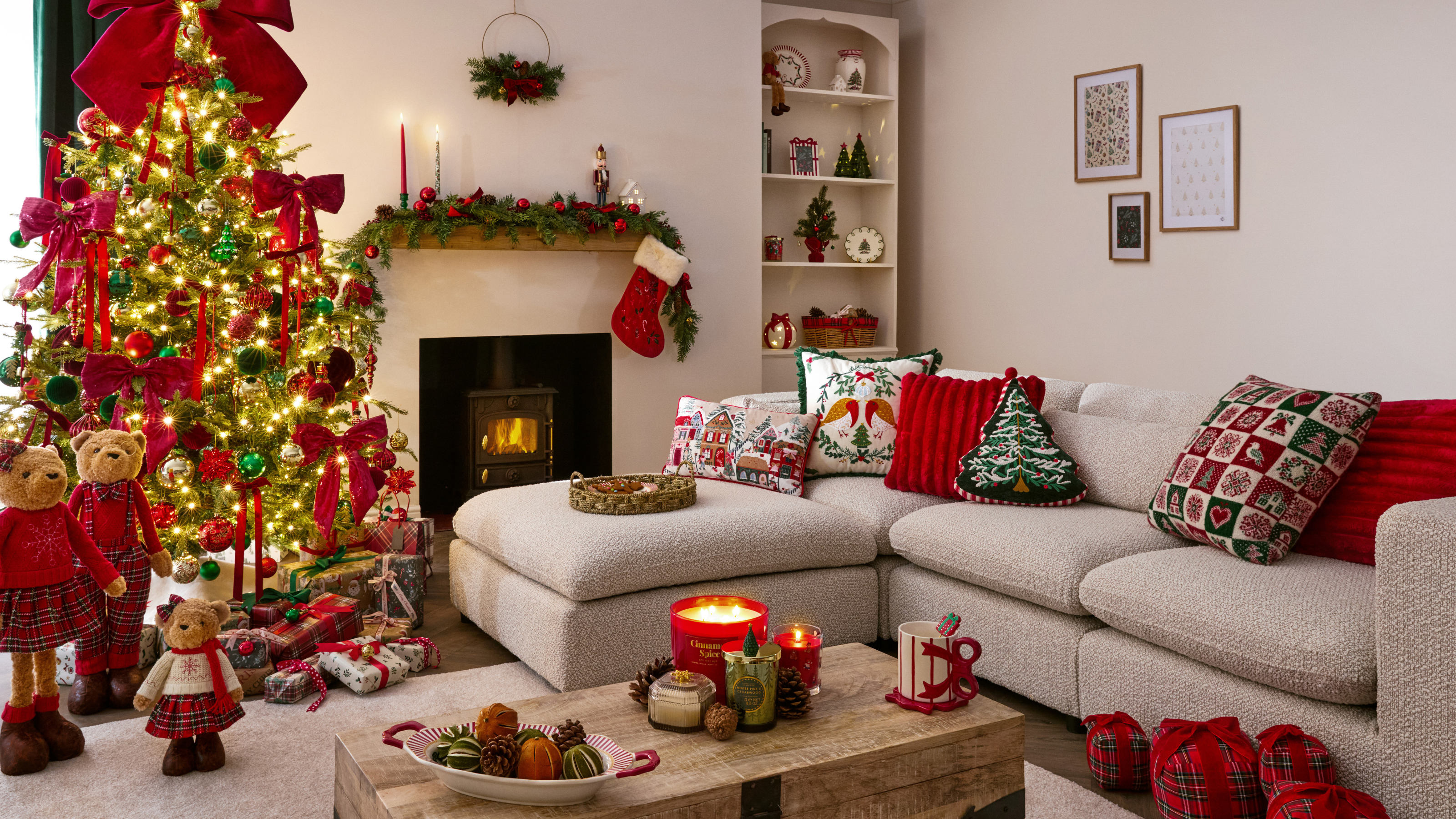 Neutral living room decorated with red christmas decor. The tree is decorated with red bows and there are teddy ornaments on the right of the tree.
