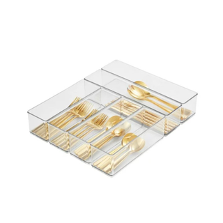 A drawer organizer with gold utensils in it