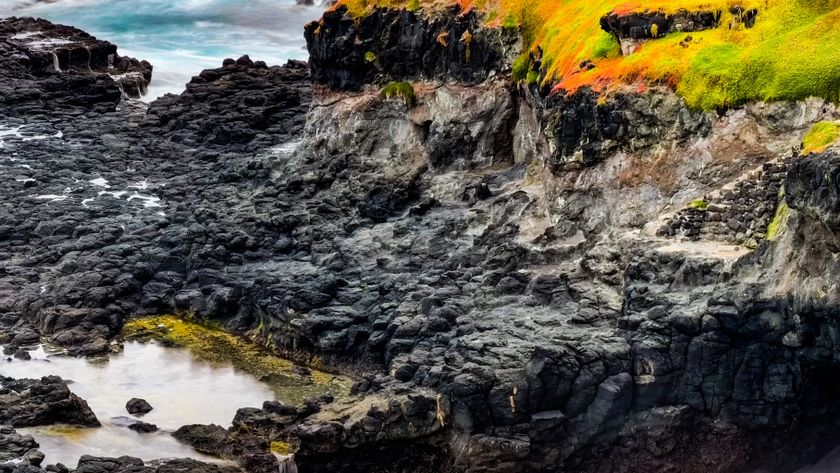 Rugged coastal landscape with rocks and colorful mineral deposits.