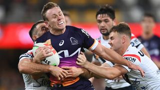Billy Walters of the Broncos is tackled by Roosters players in a 2023 match.