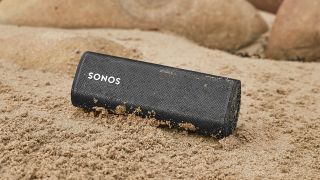 the sonos roam speaker on a sandy beach