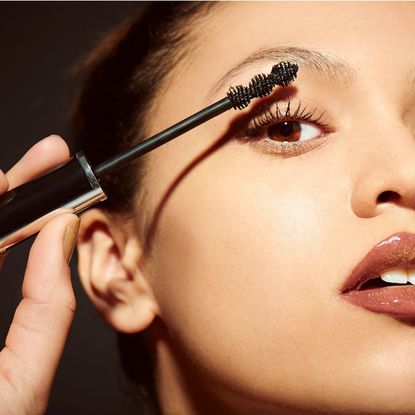 An image showing a woman applying mascara