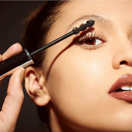 An image showing a woman applying mascara