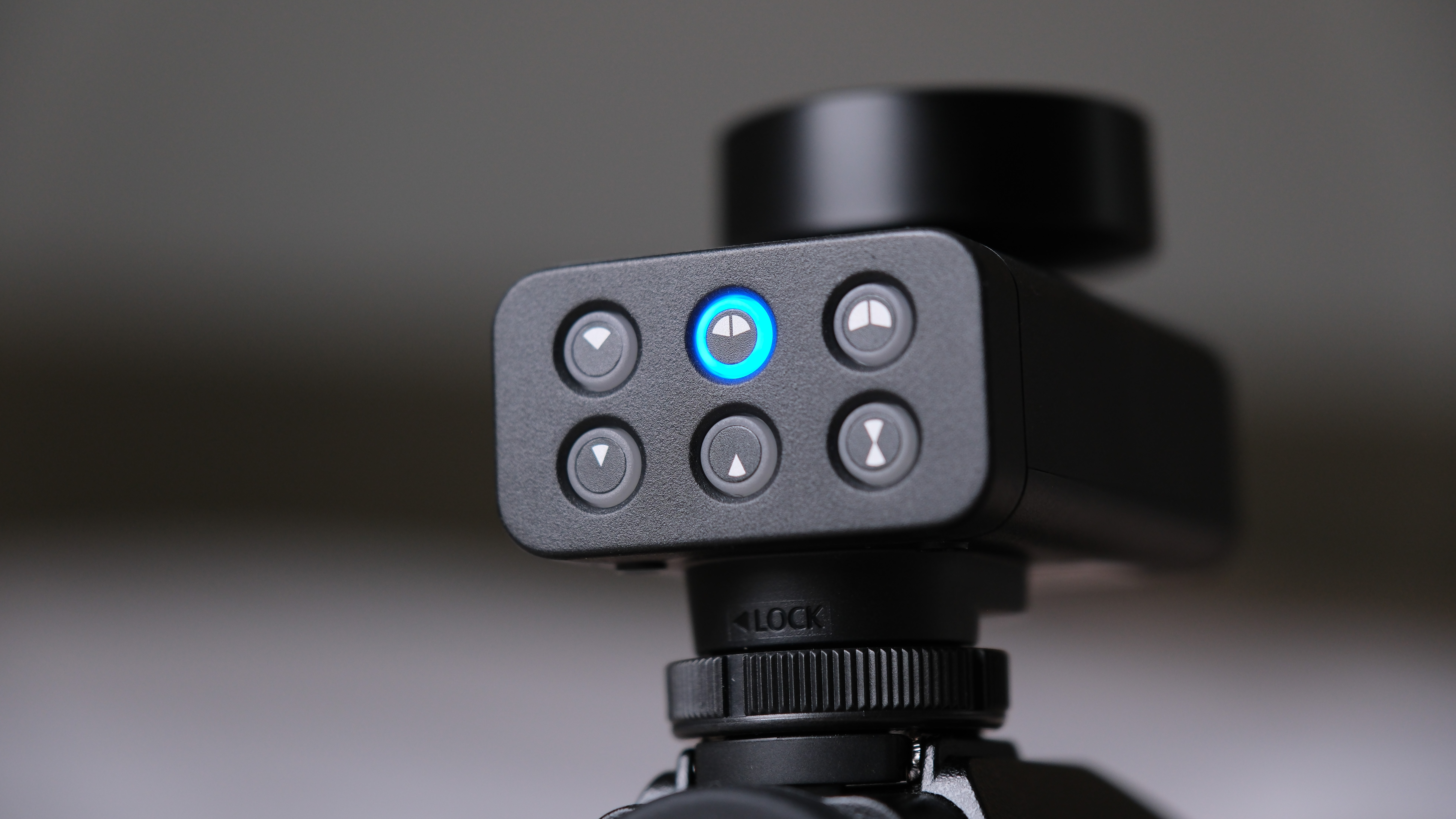 Close-up of the Panasonic Lumix DMW-DMS1 microphone control pad with illuminated blue center button and directional buttons.