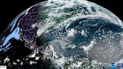 a satellite image of earth&#039;s northern hemisphere over north america, with map boarder outlines overlayed. Lots of weather is seen.