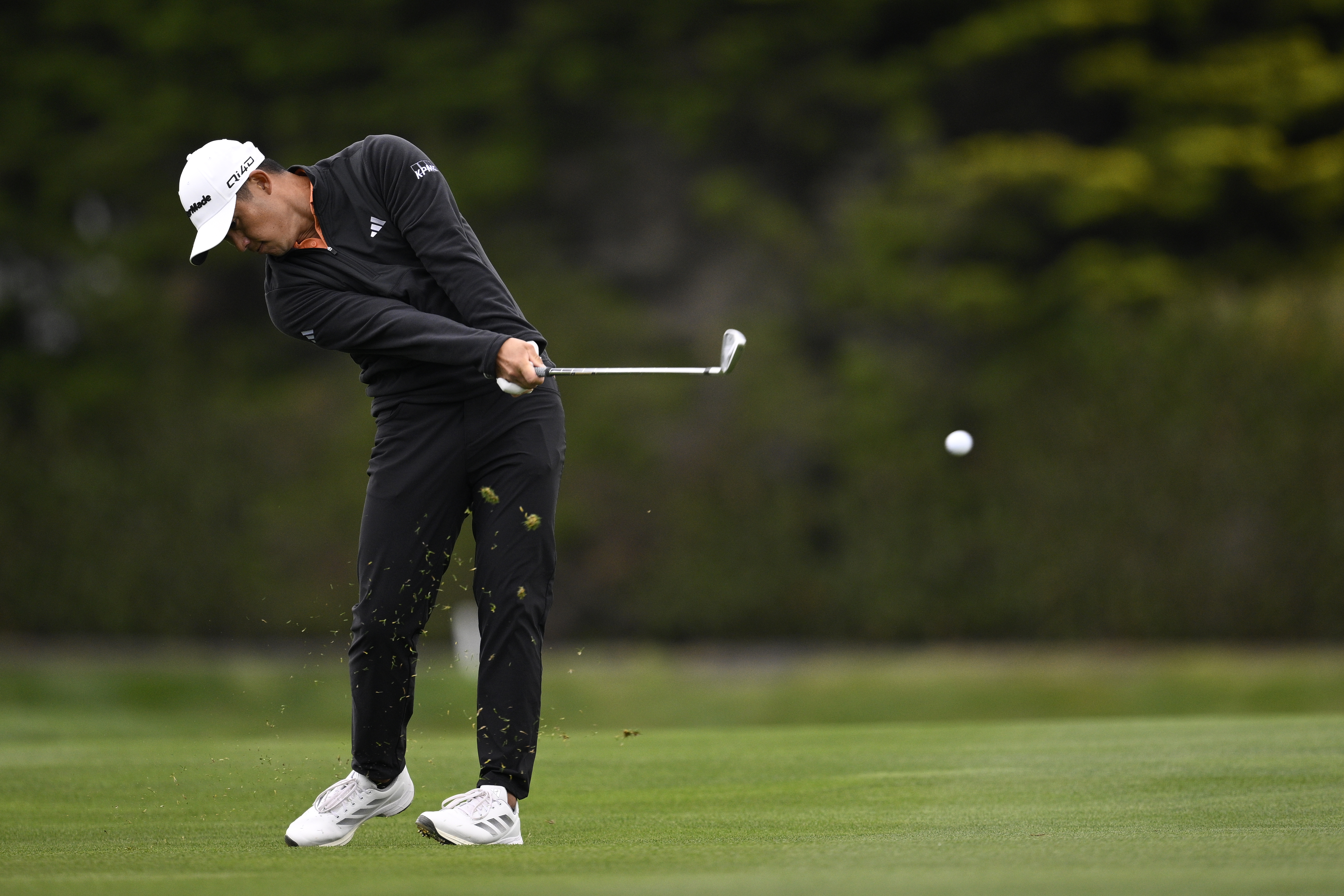 Collin Morikawa hits an iron from the fairway