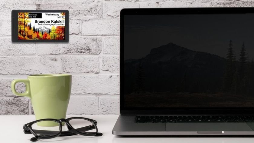 Visix e-paper solutions on a wall in front of a coffee and laptop.