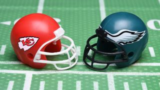 Super Bowl LVII Chiefs and Eagles helmets on gren gridiron