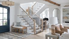 entryway going into open plan living, checkered white and light blue floor, jute bench, white walls