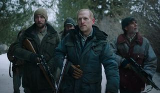 Character actor Scott Shepherd and some tough customers walking through the snow while holding guns.