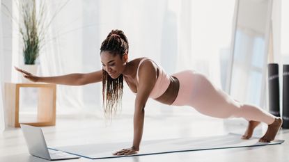 Young woman doing a runner's core workout at home