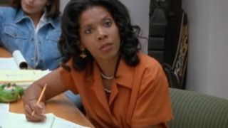 Penny Johnson Jerald in an orange blouse looking annoyed in The Larry Sanders Show