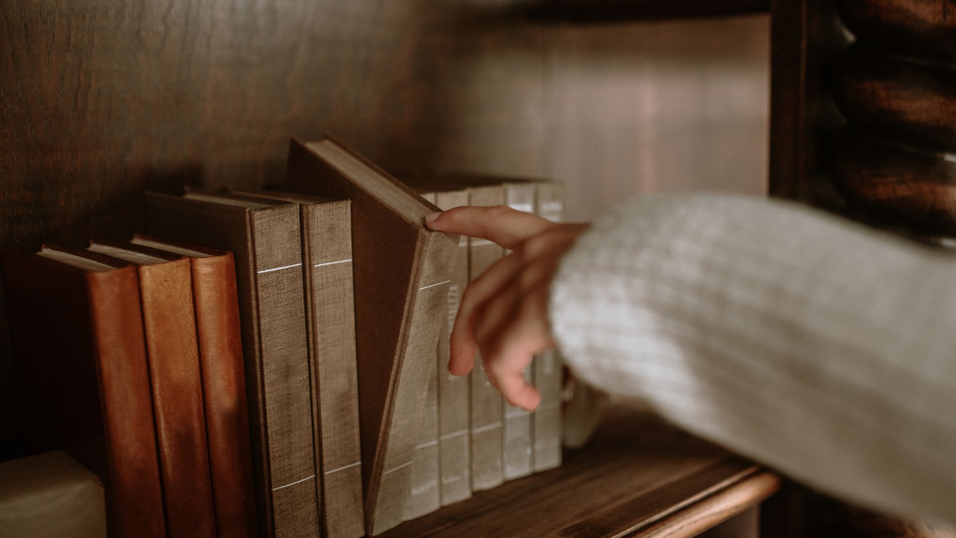 How to sell books online - Woman choosing book from shelf
