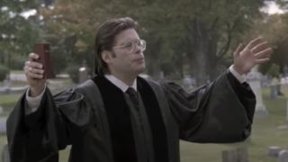 Stephen King as a priest holding his arms up in Pet Sematary