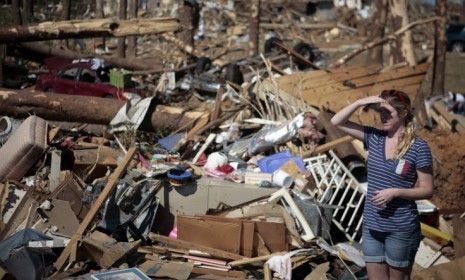 A woman surveys the damage of Thursday&amp;#039;s tornados in Tuscaloosa, Alabama, where 900 people have been injured and, unofficially, more than 40 people killed.