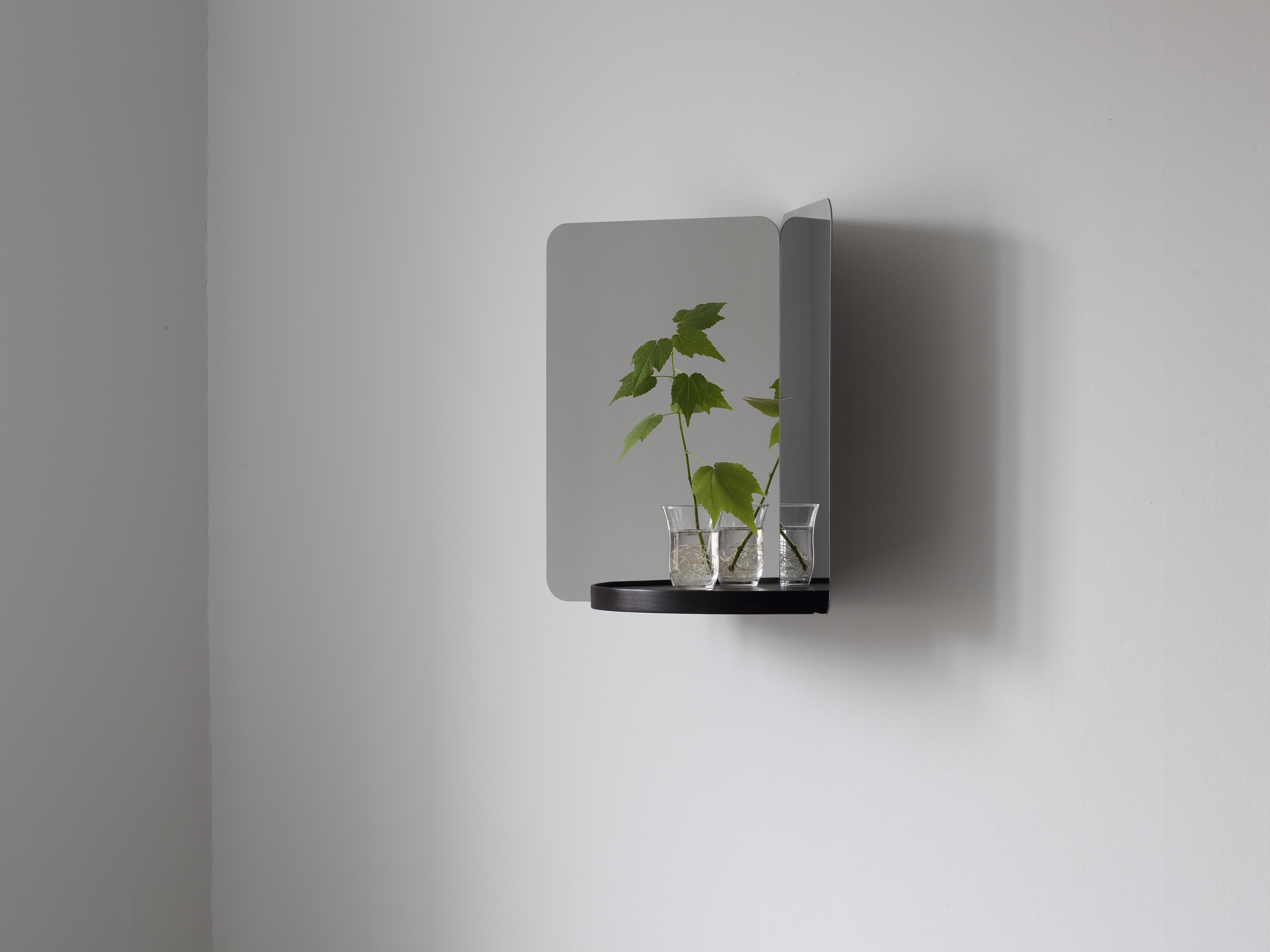 Mirror formed of two reflecting surfaces and black tray, by Daniel Rybakken for Artek