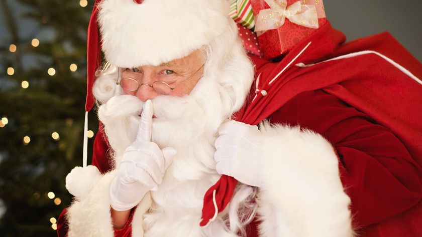 Father Christmas putting his finger to his lips with a sack of presents over his shoulder