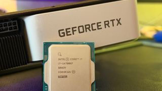 A photograph of an Intel Core i7 14700K processor resting against an Nvidia GeForce RTX 3060 Ti Founders Edition graphics card