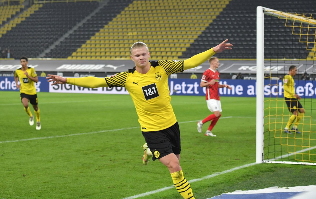 Borussia Dortmund striker Erling Haaland running with his arms outstretched, celebrating after scoring a goal