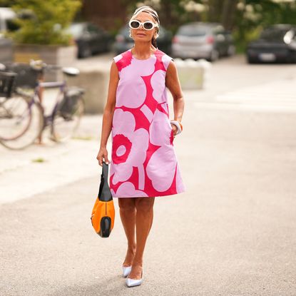 a woman wearing a floral shift dress in street style