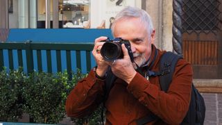 A man holding the Olympus OM-D E-M5 Mark III to his eye
